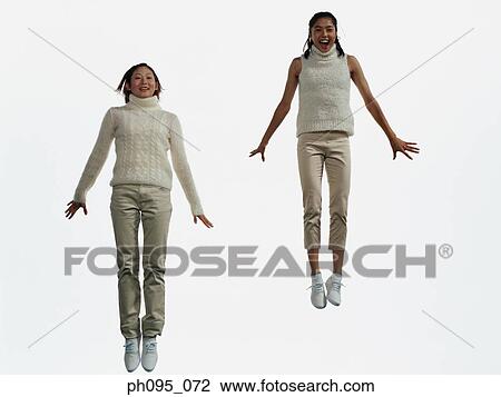 Two young Asian women in pants & sweat-shirts, jumping in mid-air View Large Photo Image Stock Image - Two young Asian women in pants & sweat-shirts, jumping in mid-air. Fotosearch