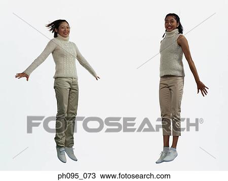 Two young Asian women in pants & sweat-shirts, jumping in mid-air View Large Photo Image Stock Image - Two young Asian women in pants & sweat-shirts, jumping in mid-air. Fotosearch