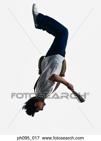 Young Asian man in jeans & t-shirt, and magazine, jumping in mid-air View Large Photo Image Stock Photo - Young Asian man in jeans & t-shirt, and magazine, jumping in mid-air. Fotosearch