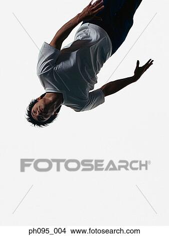 Young Asian man in jeans & t-shirt, jumping in mid-air View Large Photo Image Picture - Young Asian man in jeans & t-shirt, jumping in mid-air. Fotosearch