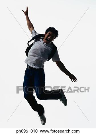 Young Asian man in jeans & t-shirt, carrying haversack, jumping in mid-air View Large Photo Image Stock Image - Young Asian man in jeans & t-shirt, carrying haversack, jumping in mid-air. Fotosearch
