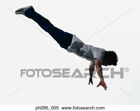 Stock Photography - Young Asian man in jeans & t-shirt, jumping in mid-air. Fotosearch