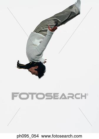 Young Asian man in pants & sweat-shirt and scarf, jumping in mid-air View Large Photo Image Picture - Young Asian man in pants & sweat-shirt and scarf, jumping in mid-air. Fotosearch
