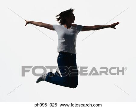 Stock Photography - Young Asian woman in jeans & t-shirt, jumping in mid-air. Fotosearch