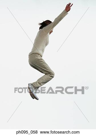 Young Asian woman in pants & sweat-shirt, jumping in mid-air View Large Photo Image Stock Photo - Young Asian woman in pants & sweat-shirt, jumping in mid-air. Fotosearch
