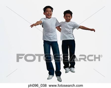 Two young Asian boys in jeans & t-shirt, jumping in mid-air View Large Photo Image Stock Photo - Two young Asian boys in jeans & t-shirt, jumping in mid-air. Fotosearch