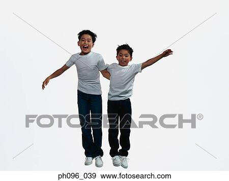 Two young Asian boys in jeans & t-shirt, jumping in mid-air View Large Photo Image Stock Photo - Two young Asian boys in jeans & t-shirt, jumping in mid-air. Fotosearch