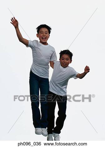 Two young Asian boys in jeans & t-shirt, jumping in mid-air View Large Photo Image Stock Photograph - Two young Asian boys in jeans & t-shirt, jumping in mid-air. Fotosearch
