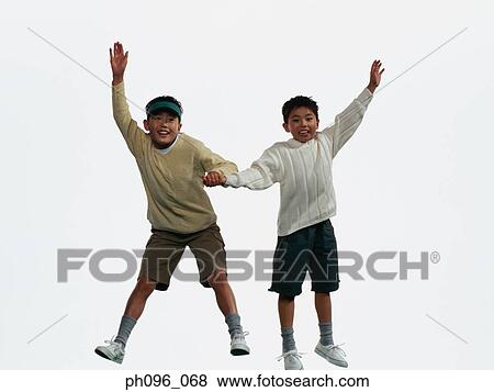 Two young Asian boys in shorts & sweat-shirts, jumping in mid-air View Large Photo Image Stock Photo - Two young Asian boys in shorts & sweat-shirts, jumping in mid-air. Fotosearch