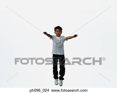 Young Asian boy in jeans & t-shirt, jumping in mid-air View Large Photo Image Picture - Young Asian boy in jeans & t-shirt, jumping in mid-air. Fotosearch