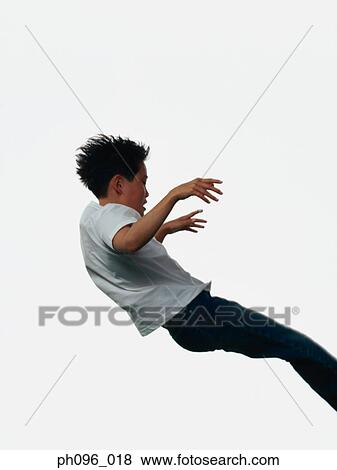 Young Asian boy in jeans & t-shirt, jumping in mid-air View Large Photo Image Stock Photo - Young Asian boy in jeans & t-shirt, jumping in mid-air. Fotosearch