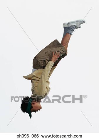 Stock Photograph - Young Asian boy in shorts & sweat-shirt, jumping in mid-air. Fotosearch