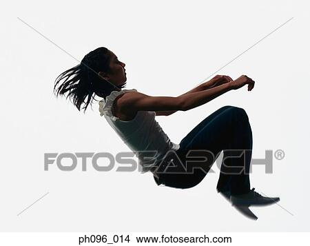 Picture - Young Asian girl in jeans & t-shirt, jumping in mid-air. Fotosearch