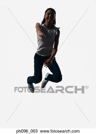 Stock Image - Young Asian girl in jeans & t-shirt, jumping in mid-air. Fotosearch