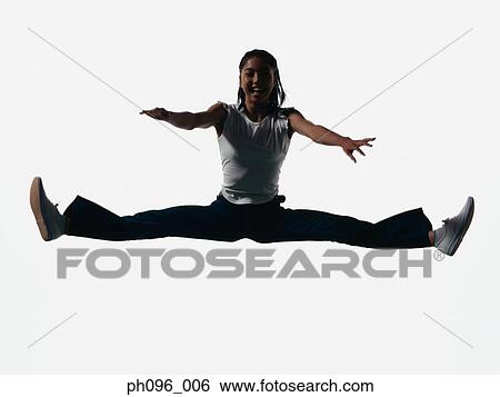 Stock Photograph - Young Asian girl in jeans & t-shirt, jumping in mid-air. Fotosearch