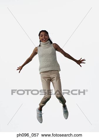 Stock Photo - Young Asian girl in shorts & cardigan, jumping in mid-air. Fotosearch