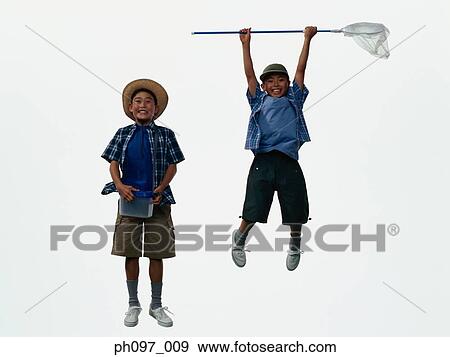 Two young Asian boys in camping outfit, jumping in mid-air View Large Photo Image Stock Photo - Two young Asian boys in camping outfit, jumping in mid-air. Fotosearch