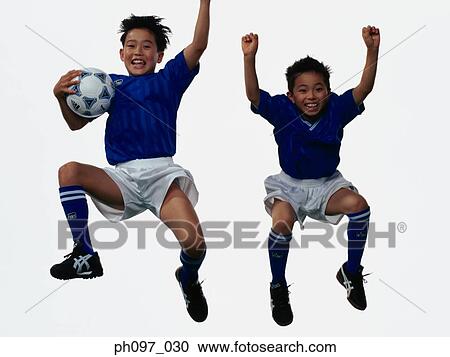 Two young Asian boys playing football in mid-air View Large Photo Image Stock Image - Two young Asian boys playing football in mid-air. Fotosearch