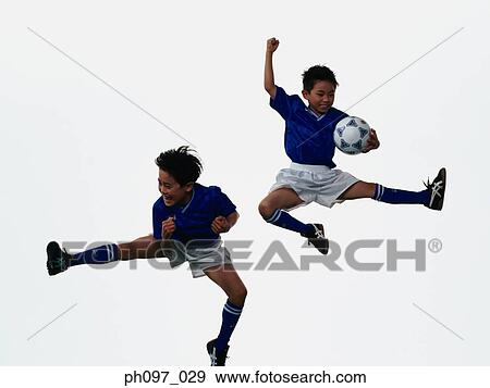 Stock Photo - Two young Asian boys playing football in mid-air. Fotosearch