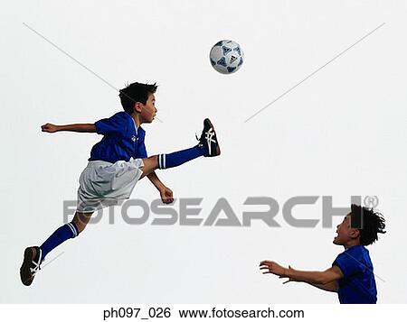 Two young Asian boys playing football in mid-air View Large Photo Image Stock Photograph - Two young Asian boys playing football in mid-air. Fotosearch