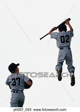 Stock Image - Two young baseball players jumping in mid-air. Fotosearch