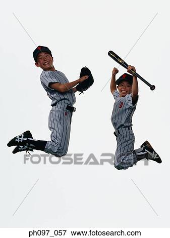 Stock Photo - Two young baseball players jumping in mid-air. Fotosearch