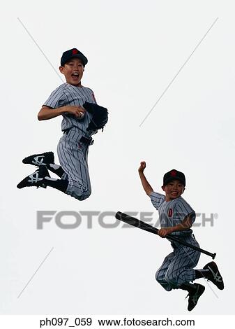 Stock Photo - Two young baseball players jumping in mid-air. Fotosearch