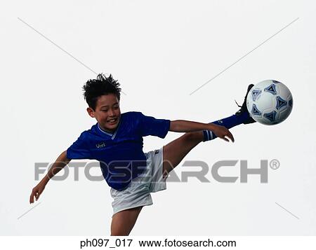 Young Asian boy kicking football in mid air View Large Photo Image Stock Photo - Young Asian boy kicking football in mid air. Fotosearch