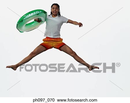 Young Asian girl holding inflated ring, jumping in mid-air View Large Photo Image Stock Image - Young Asian girl holding inflated ring, jumping in mid-air. Fotosearch