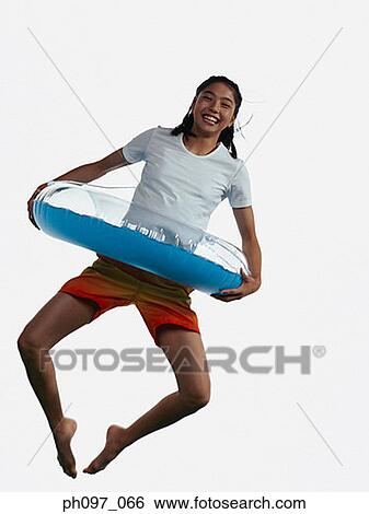 Young Asian girl with inflated ring, jumping in mid-air View Large Photo Image Stock Photograph - Young Asian girl with inflated ring, jumping in mid-air. Fotosearch