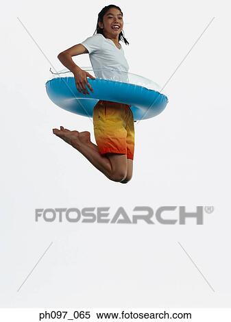 Young Asian girl with inflated ring, jumping in mid-air View Large Photo Image Stock Photography - Young Asian girl with inflated ring, jumping in mid-air. Fotosearch