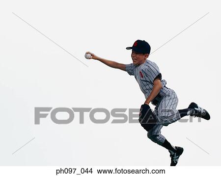 Picture - Young Baseball player catching ball in glove in mid-air. Fotosearch