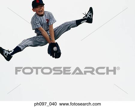 Young Baseball player catching ball in glove in mid-air View Large Photo Image Stock Image - Young Baseball player catching ball in glove in mid-air. Fotosearch