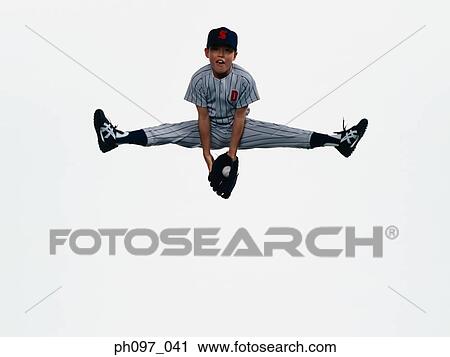 Stock Image - Young Baseball player catching ball in glove in mid-air. Fotosearch