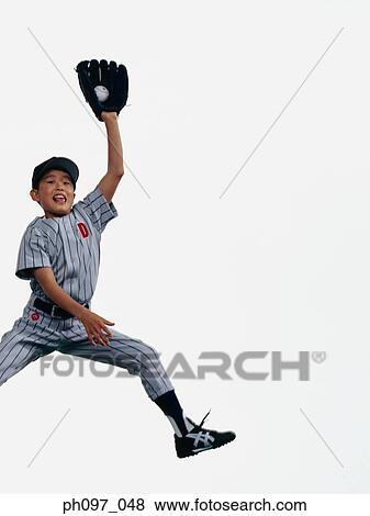 Young Baseball player catching ball in glove in mid-air View Large Photo Image Stock Photo - Young Baseball player catching ball in glove in mid-air. Fotosearch