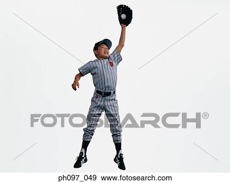 Stock Photo - Young Baseball player catching ball in glove in mid-air. Fotosearch