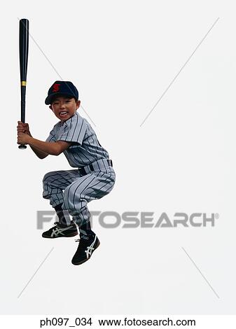Picture - Young Baseball player holding bat in mid-air. Fotosearch