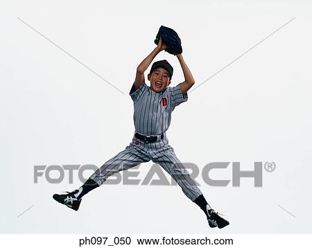 Stock Image - Young Baseball player in baseball glove, jumping in mid-air. Fotosearch