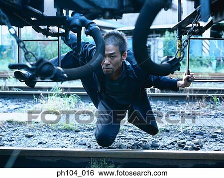 Man hiding under a train View Large Photo Image Stock Photograph - Man hiding under a train. Fotosearch