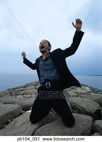 Man kneeling, arms raised, shouting View Large Photo Image Stock Image - Man kneeling, arms raised, shouting . Fotosearch