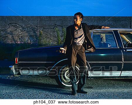 Man leaning against car View Large Photo Image Stock Photo - Man leaning against car. Fotosearch