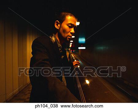 Man leaning against railing, at night View Large Photo Image Stock Photo - Man leaning against railing, at night. Fotosearch