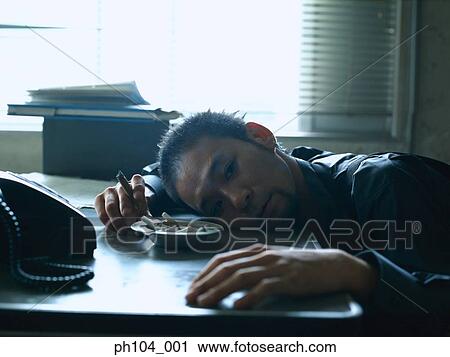 Man resting head on table, hand holding cigarette View Large Photo Image Stock Image - Man resting head on table, hand holding cigarette. Fotosearch
