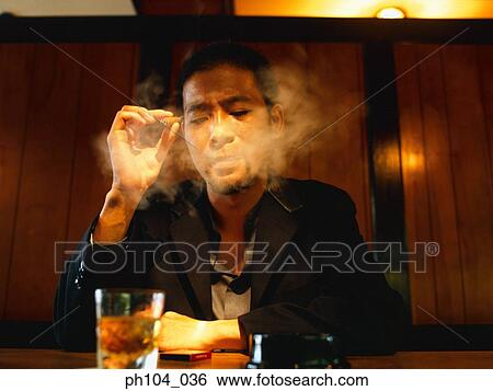 Stock Photograph - Man sitting at a bar, smoking. Fotosearch