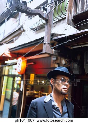 Man with hat, walking on the street View Large Photo Image Stock Photo - Man with hat, walking on the street. Fotosearch
