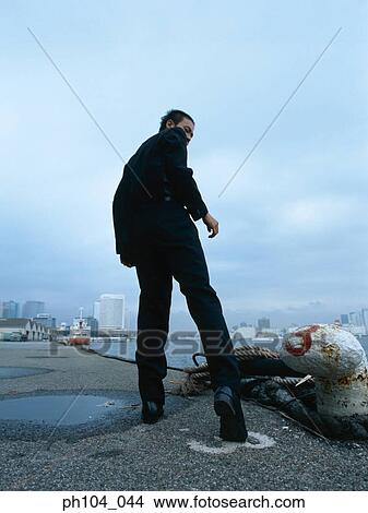Picture - Rear view of a man at jetty. Fotosearch