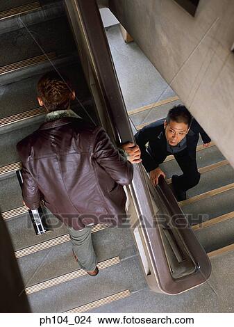 Two men climbing stairs, elevated view View Large Photo Image Picture - Two men climbing stairs, elevated view . Fotosearch