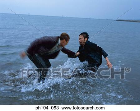 Two men fighting at the beach View Large Photo Image Stock Image - Two men fighting at the beach. Fotosearch