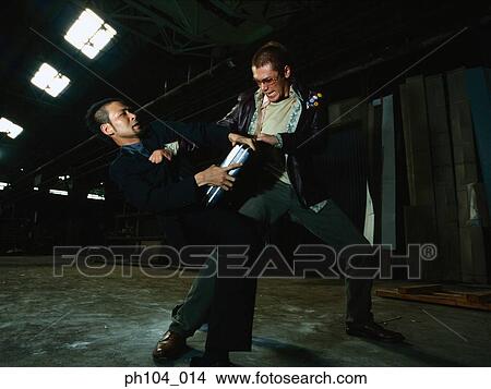 Picture - Two men struggling over a briefcase. Fotosearch