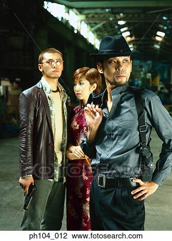 Stock Image - Two men with guns and a lady in Chinese costume. Fotosearch